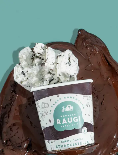 Pot de glace Stracciatella Raugi présenté sur fond chocolat